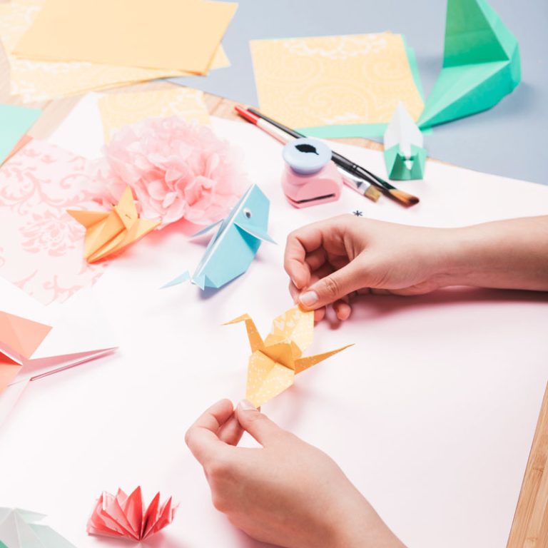 overhead-view-human-hand-holding-origami-bird-table